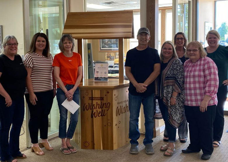 people stand around a well