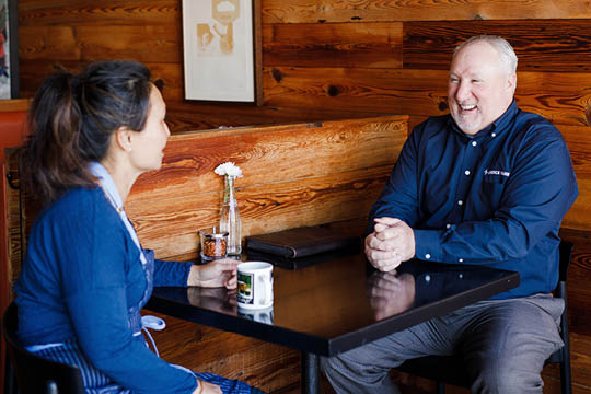 Bob sitting at a table with customer.