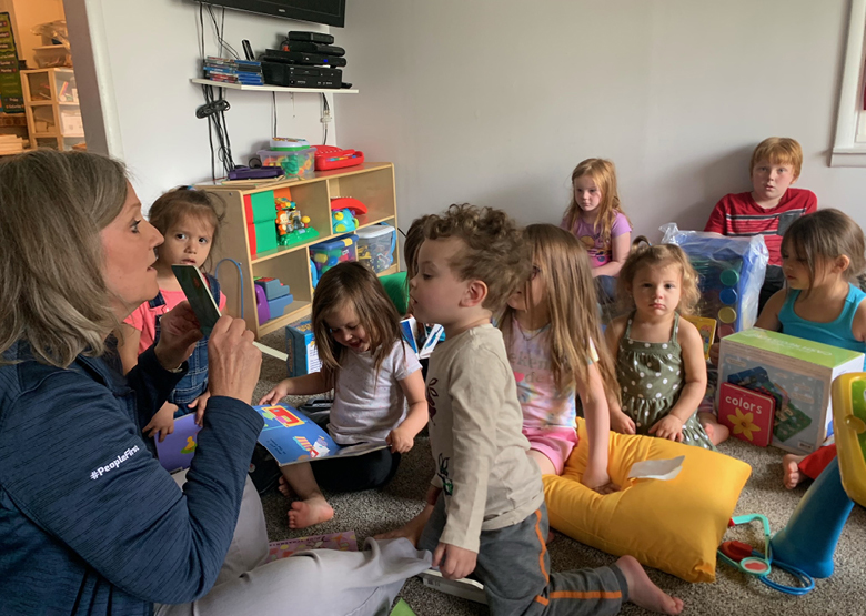 Children listen to woman read book